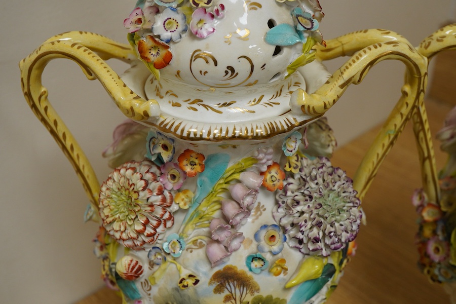 A pair of English porcelain floral encrusted vases and covers, c.1830, possibly Samuel Alcock, each painted with landscapes, 44cm high